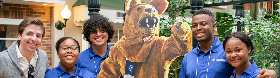 diverse group of students poses with cardboard nittany lion cutout