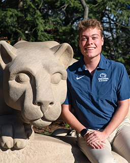 clayton geisel standing by the nittany lion shrine